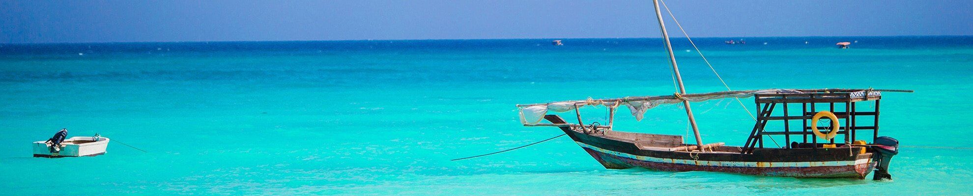 Zanzibar beach at sunset with traditional dhow